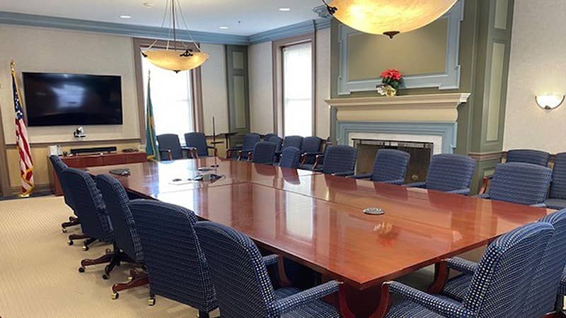 A new meeting room with a large conference table and multiple chairs.